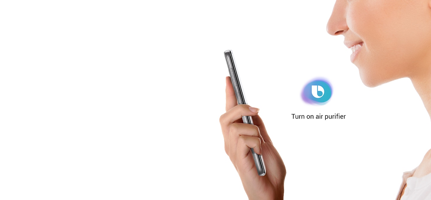 Side view of a woman looking at Galaxy S9 Orchid Gray and saying 'Turn on air purifier'