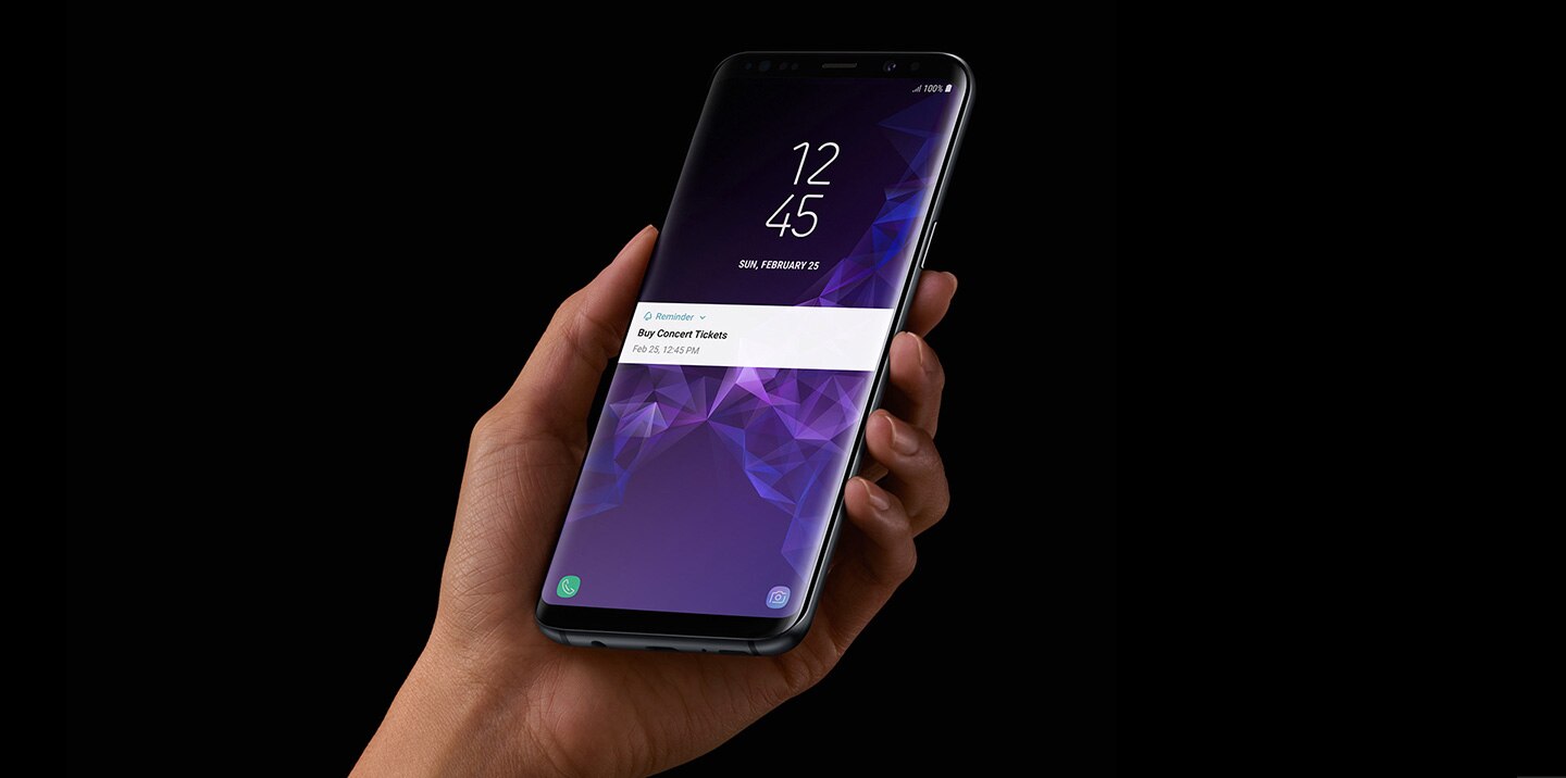 Image d'une main gauche tenant un Galaxy S9 Midnight Black avec la fonction Rappel de l'application Bixby en cours d'exécution.