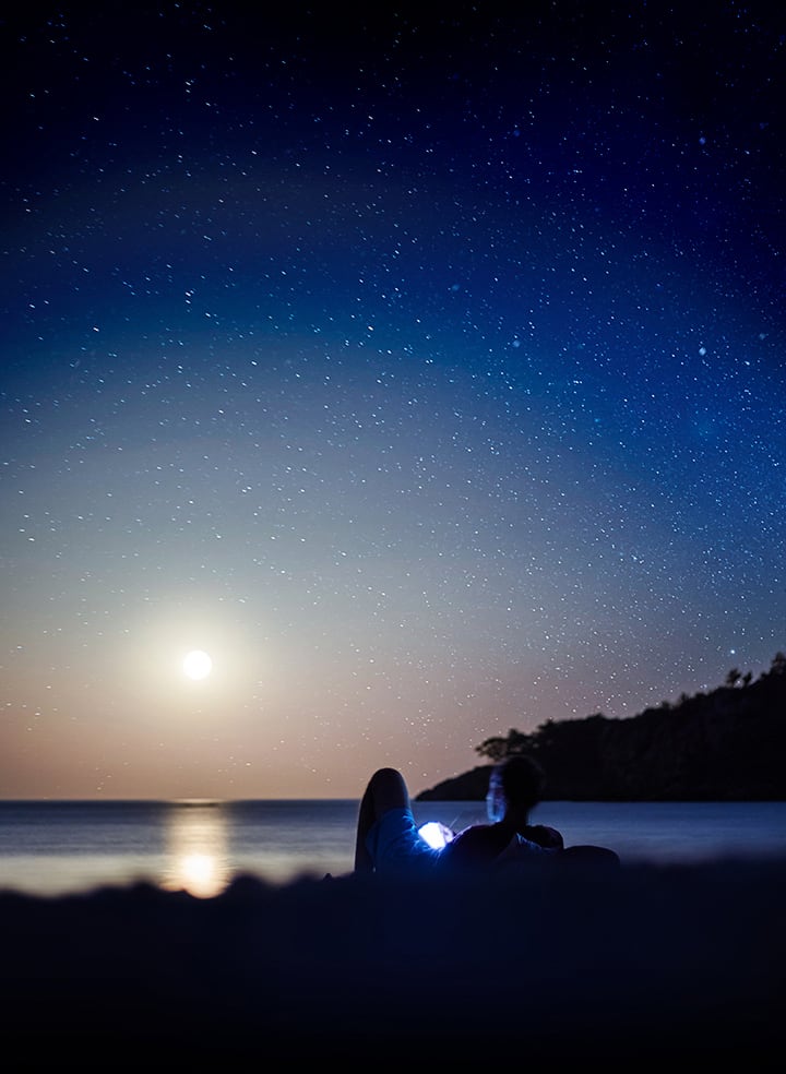 For the achievers out there Background image of a person sitting outside in the dark, looking at a glowing Galaxy Note9