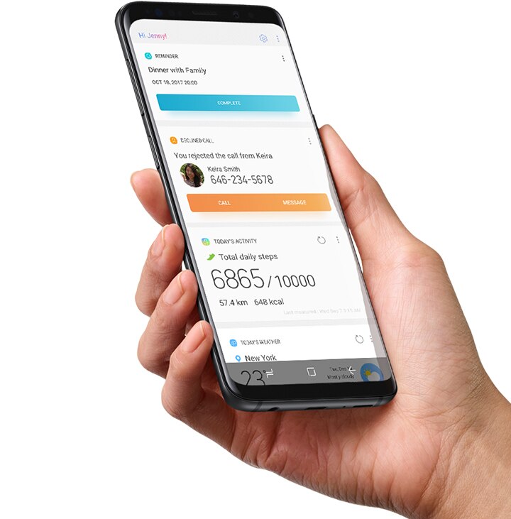 Seseorang memegang Galaxy S9 Midnight Black yang menjalankan Beranda Bixby yang diatur di aplikasi DECLINED CALL, TODAY'S ACTIVITY, TODAY'S WEATHER di tangan kanannya.