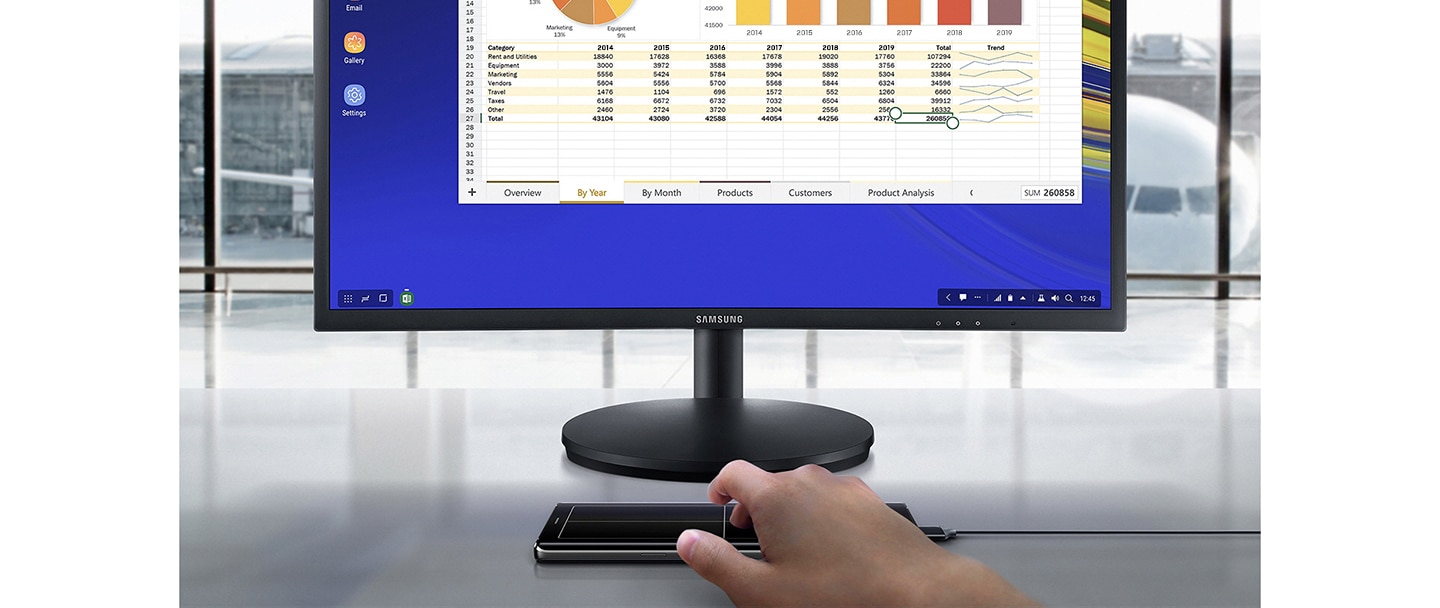 a monitor showing a microsoft excel spreadsheet onscreen in dex mode a man uses a - fortnite samsung dex