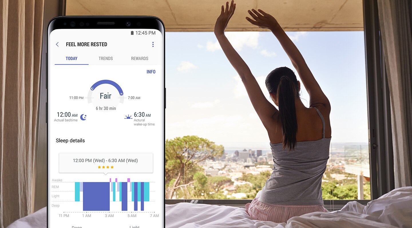 Vue avant du Galaxy S9 Midnight Black avec l'application Health pour vérifier et gérer le temps de sommeil en haut à droite de la femme qui s'étire sur le lit