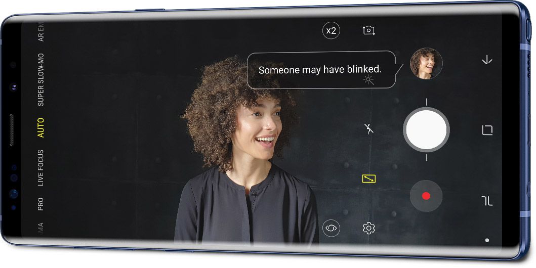 Το Galaxy Note9 σε οριζόντια λειτουργία όπως φαίνεται υπό γωνία με ένα πορτρέτο και τη διεπαφή ανίχνευσης ατελειών στην οθόνη, με την ειδοποίηση «Κάποιος ίσως να ανοιγόκλεισε τα μάτια του».