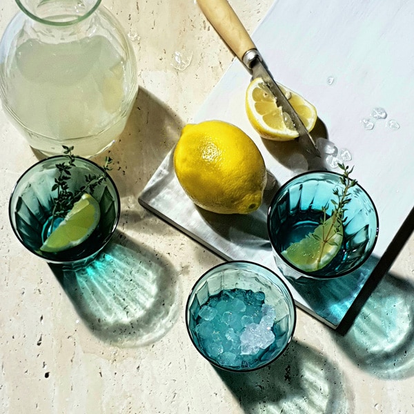 A photo taken by Galaxy Note9 of blue glasses surrounded by lemons, casting shadows on the table