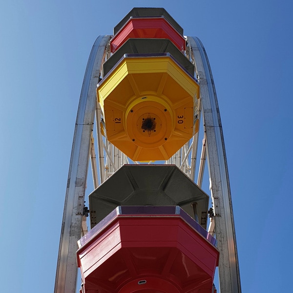 A photo taken by Galaxy Note9 looking upwards, with a colorful ferris wheel against a cloudless blue sky