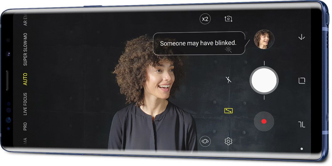 Galaxy Note9 in landscape mode seen at an angle with a portrait and the Flaw Detection interface onscreen, saying âSomeone may have blinked.â